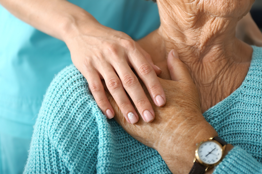 Nurse holding patient's hand.