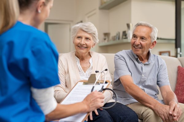 Elderly couple at home with health care provider